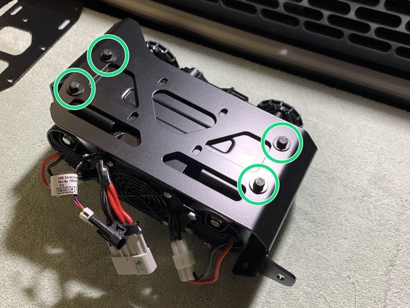 With the mounting holes of the ARB Twin compressor facing up, set the Grimm OffRoad Main Bracket into the Compressor oriented as shown.