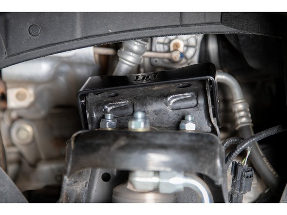 Slide the new upper control arm bucket bracket over the upper control arm frame mount. The cutout should be toward the motor.