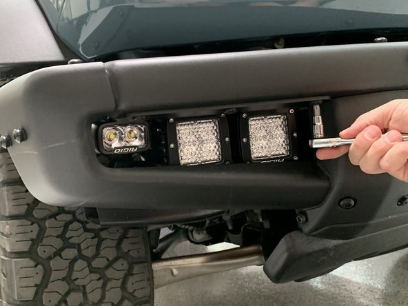 Attach Aux Light Mounting Brackets to the steel bumper using the screws removed earlier.