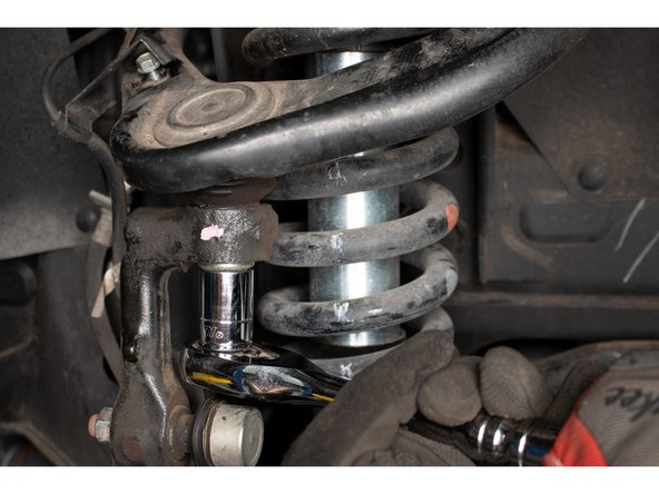 Using a 19mm socket or wrench, loosen the upper ball joint nut. Do not remove the nut, leave a few threads engaged.