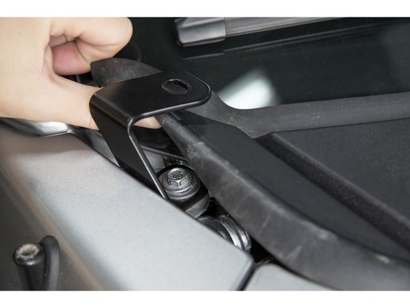 Align the bracket to the edge of the fender and tighten the cowl fender bolt with a 10mm socket.