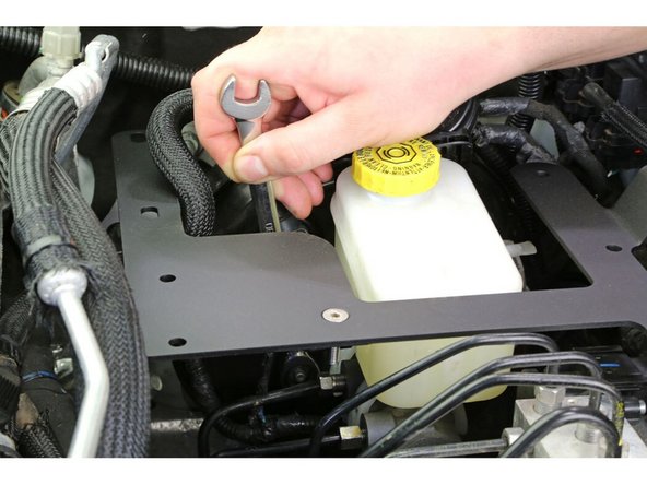 Tighten the nut holding the compressor mount gusset to the master cylinder flange.