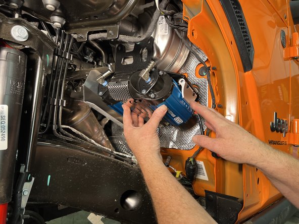 Reinstall the OE nuts onto the firewall studs to secure the bottom of the Grimm OffRoad compressor mounting bracket.