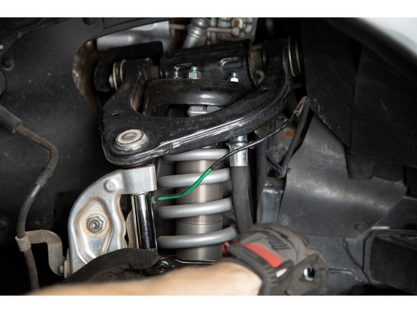 Using a 18mm socket or wrench, loosen the upper ball joint nut. Do not remove the nut, leave a few threads engaged.