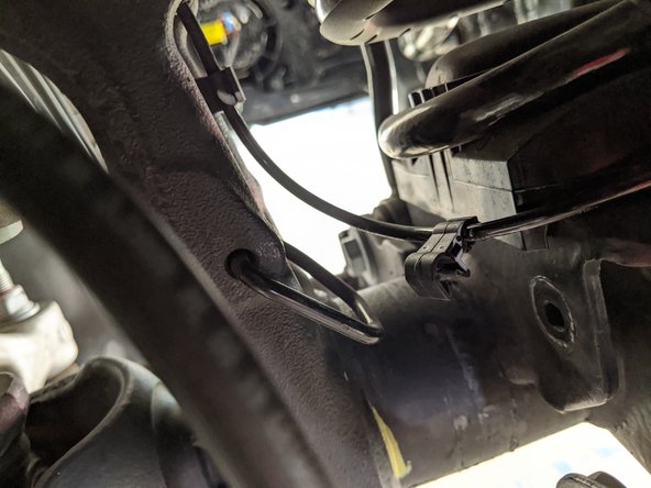 Unclip the wheel sensor wire from the bracket on the upper C.