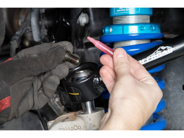 Remove the 1/2-20 12 point cap screws from the top of the uniballs.  Apply provided threadlocker to the threads, and re-install.