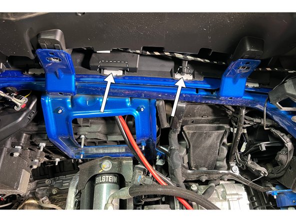 Using diagonal cutters, trim the plastic covering the center two fender flare clips as shown.