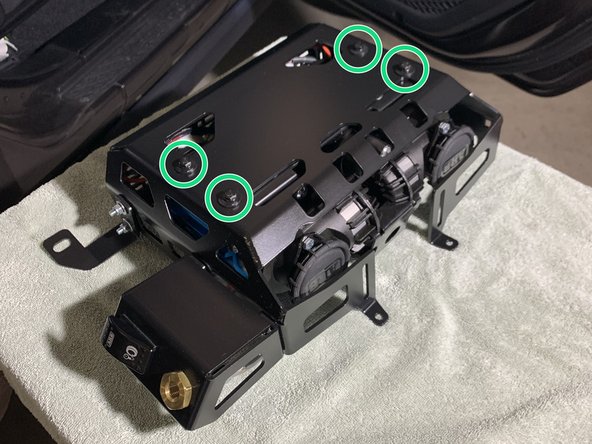 With the mounting holes of the ARB Twin compressor facing up, set the Grimm OffRoad Bracket onto the Compressor oriented as shown.