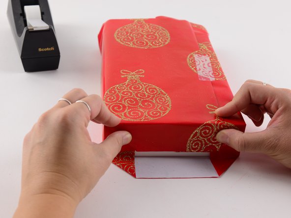 Fold down the top flap of the wrapping paper and make a crease.