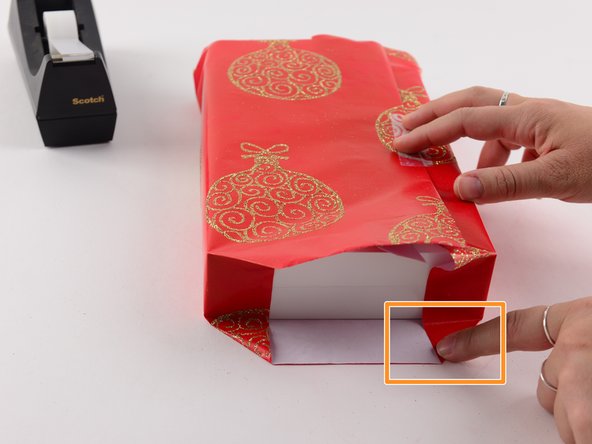 Use two fingers to push in the u-shaped edge of the wrapping paper.