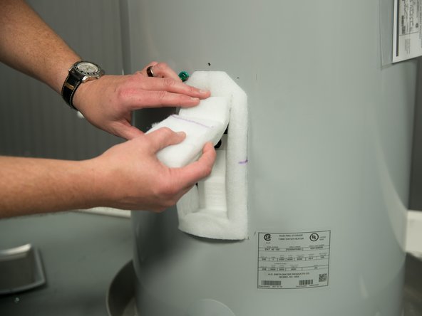 Move the insulation out of the way (tuck the insulation under the water heater's jacket).