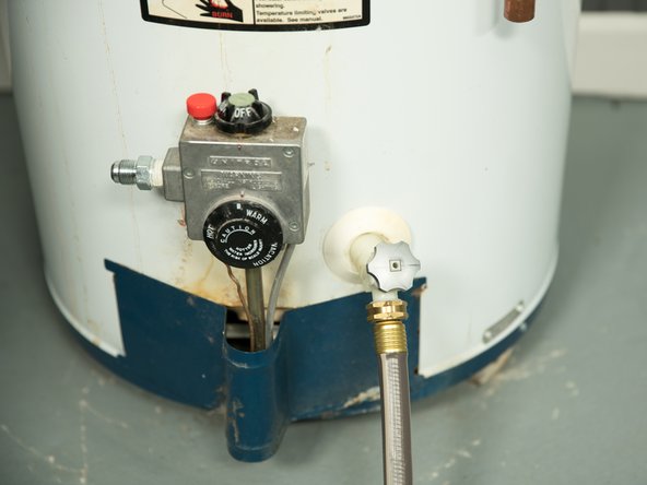 Some drain valves may be opened with a handle but others require a flat blade screwdriver. 