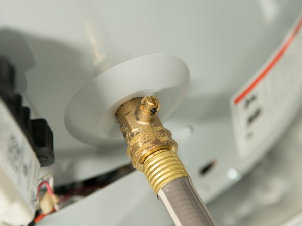 Some drain valves may be opened with a handle but others require a flat blade screwdriver. 