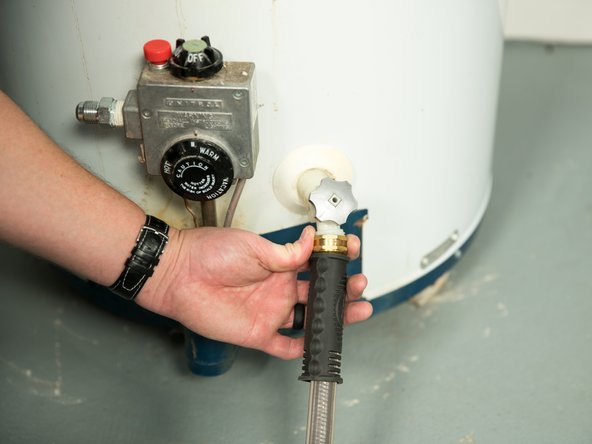 Connect a garden hose to the water heater's drain valve and place the other end of the hose in a drain, outside, or in a bucket.