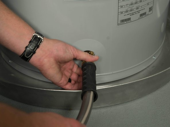 Connect a garden hose to the water heater's drain valve and place the other end of the hose in a drain, outside, or in a bucket.