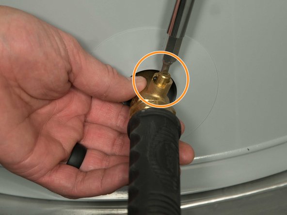 Some drain valves may be opened with a handle but others require a flat-blade screwdriver. 