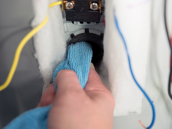 Clean the threads in the tank opening with a rag.