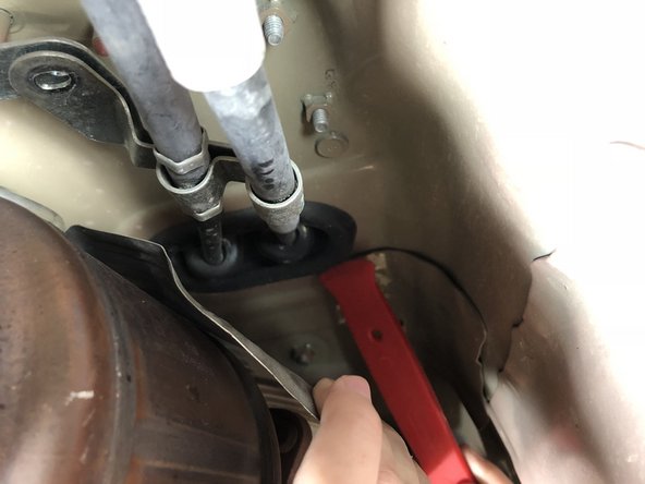 Using a plastic pry tool or flathead screwdriver, work your way around the edge of the shifter cable seal.