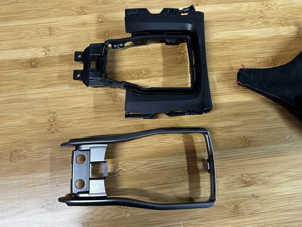 You can now remove the trim ring from the console cover. Depress the tabs and push the ring out.