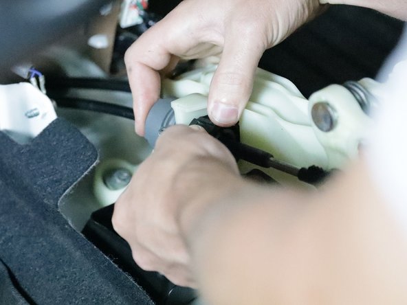 Flip the lock up and spin the shifter cable ring. This can be tough because you must spin it enough for the slot to align with the shifter. Once it aligns you can slide it out and the cable lock will twist back.