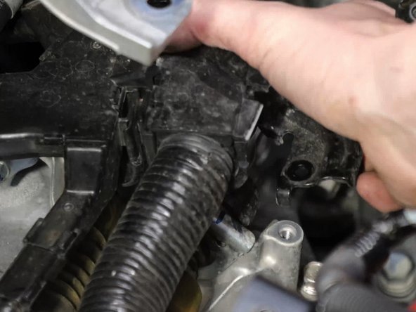 Unbolt the wiring harness and move it out of the way, exposing the shifter cables and bracket.