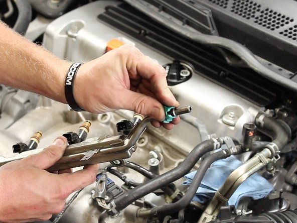 Remove the quick disconnect locking clip from the factory fuel rail and install on the new fuel rail.