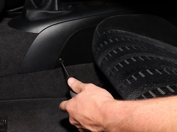 On the upper section of the center console, locate the mounting screws.