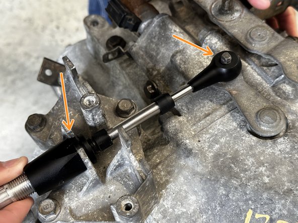 Install the shifter cable with the smaller end link on the transmission by sliding it through the cable mounting bracket.