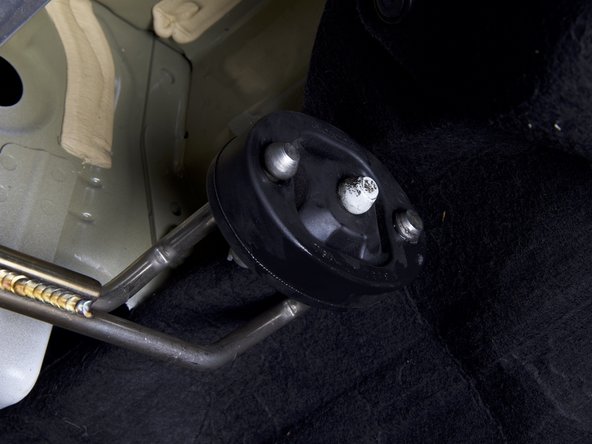 We suggest just installing one hanger through the bushings at a time. Once you have one hanger in each bushing, you can rotate the rubber and get the other one through.