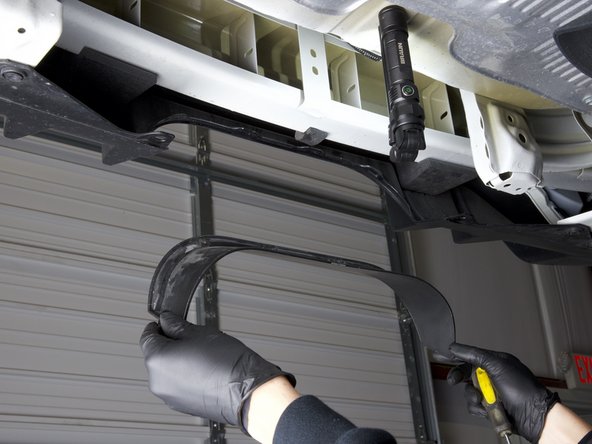 The top section of the trim is held in with molded clips. You can use a flat tipped screw driver to depress the tips and remove the trim from the bumper.