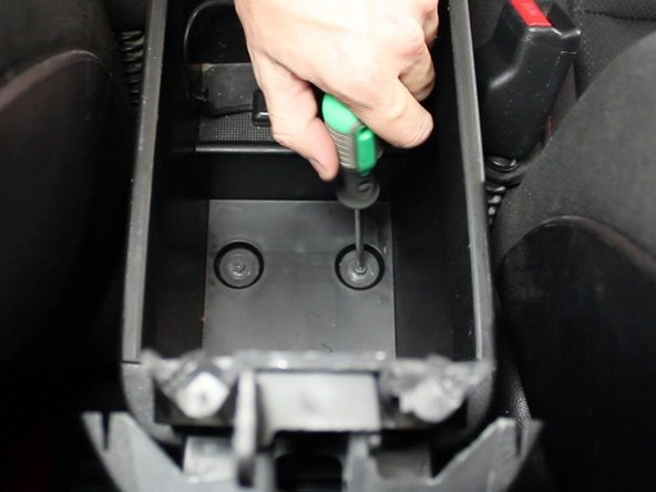 Remove the two mounting screws located inside of the center console compartment.