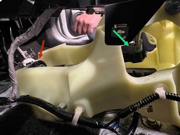 The shifter cable is secured to the shifter by a twist-lock collar. Pull the white locking tab straight out, then rotate the black collar counter-clockwise until the internal spring bottoms out (it’s stiff, so expect a few firm turns). Once the collar stops, slide the cable housing straight up out of the shifter plastic.