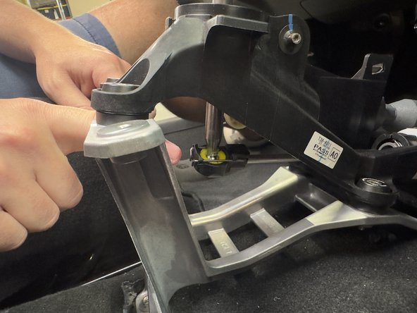 Spread the metal clip apart and pull it back on the shifter cable end. It should slide off. Then, slide the shifter cable end link away from the shifter, seperating it from the ball.