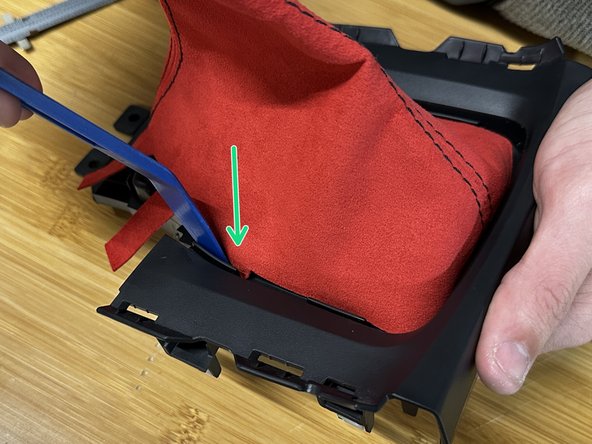 Use a trim tool, pick or flat screw driver and push the fabric through the trim. Make sure the boot is spaced evenly.