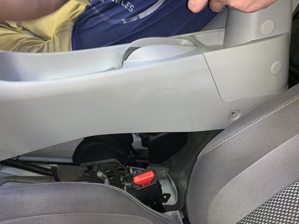 Lift the console from the rear and slide it rearward. Lift it over the shifter and remove it from the car.