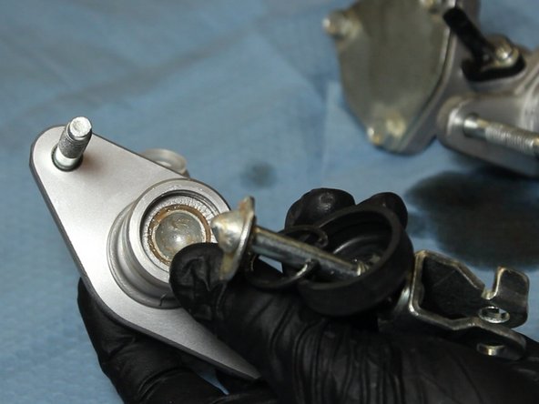 Using the C-clip pliers, remove the rod and for from the EM1 CMC.