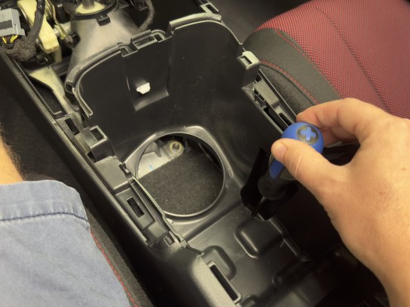 Remove the two 10mm mounting bolts under the cup holders.