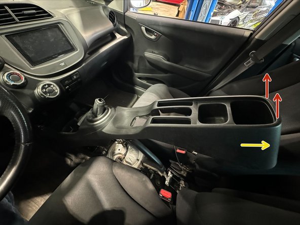 Pull UP at rear of console.