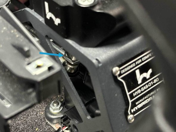 To reconnect the shifter cable, rotate the black collar counter-clockwise and slide the cable housing straight down into the shifter bracket until it is fully seated. The spring will pull the collar tight when you let go. Finish by pressing the white locking tab flush so the collar locks securely in place.