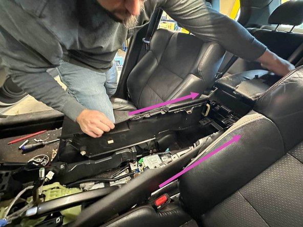 Carefully remove the center console by sliding it back and out of the car from the rear.