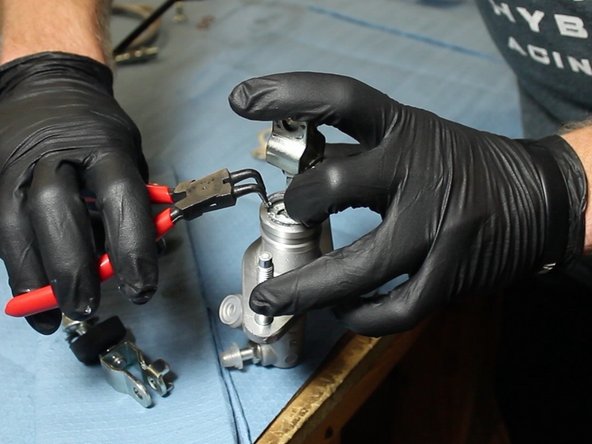 Using the C-clip pliers, insert the OEM rod &amp; fork into the EM1 CMC. The EM1 dust boot is optional.