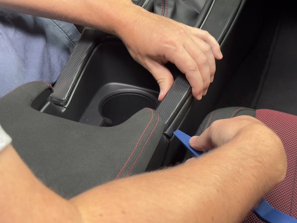 Use a plastic trim tool and unclip the upper portion of the console.