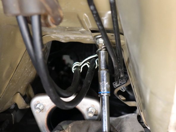 Under the car, slide the cable bracket into place and secure it back into place.