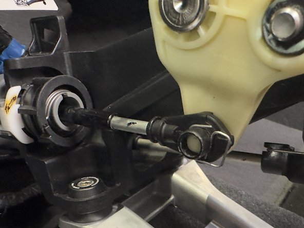 Remove the retaining clip from the shifter cable end link and slide the cable off.