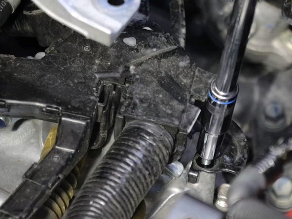 Unbolt the wiring harness and move it out of the way, exposing the shifter cables and bracket.