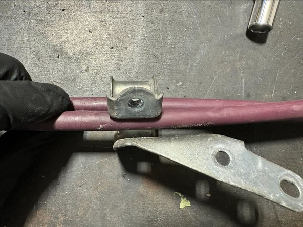 Bend bracket open so that there is large enough gap to remove OE cables.