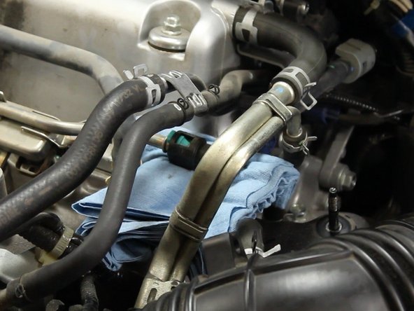 Disconnect the fuel line from the fuel rail by pressing on the release clips.
