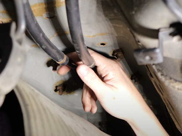 Pull the shifter cable floor seal downward and remove the cables from the cabin.