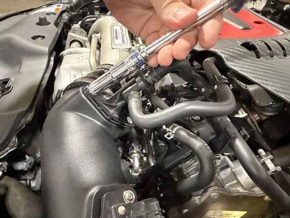 With everything aligned, position the breather hose tube into the inlet. Use the provided bolts to tighten the EVAP tube down.