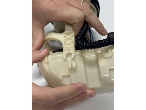 Unclip the lower fuel pump cage from the main housing.